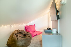 A cozy room with a bean bag, a bed with pink bedding, a desk with a computer and headphones, and string lights on the ceiling. - 7 Bed in Broadwoodkelly (oc-b45447) (Broadwood Kelly)
