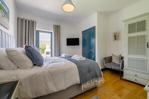 A hotel room with a bed, a TV, a wardrobe, and a window with curtains. - 5 Bed in Windmill (oc-o45436) (Trevone)