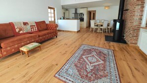 Ein großzügiger Wohnbereich mit einer Couch, einem Esstisch und einem Kamin.