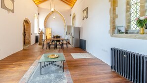 A spacious room with a wooden floor, a dining table, and a kitchen area. - 2 Bed in Market Stainton (oc-s45536) (Market Stainton)