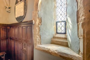 A room with a wooden wardrobe, a stone wall, and a window with a metal grille. - 2 Bed in Market Stainton (oc-s45536) (Market Stainton)