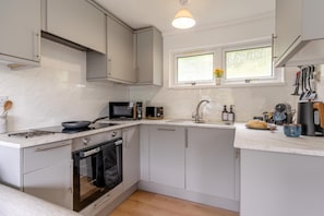A modern kitchen with a built-in oven, microwave, and sink.