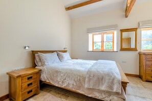 A bedroom with a bed, wooden nightstands, a dresser, a window with a view, and a mirror. - 2 Bed in Awre (oc-o45277) (Awre)