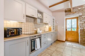 A kitchen with a built-in microwave, oven, and coffee maker.