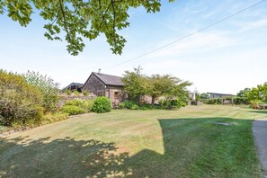 A stone house with a well-maintained lawn and a garden area. - 2 Bed in Awre (oc-o45277) (Awre)