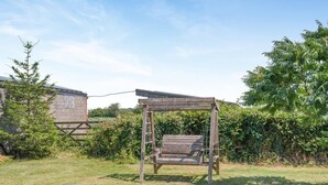 A wooden swing set in a grassy outdoor area with a building in the background. - 2 Bed in Awre (oc-o45277) (Awre)