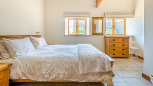 A bedroom with a bed, dresser, mirror, and two windows with shutters. - 2 Bed in Awre (oc-o45277) (Awre)