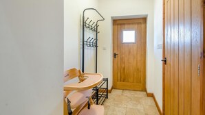 A narrow hallway with a wooden door, a coat rack, and a small table with chairs. - 2 Bed in Awre (oc-o45277) (Awre)