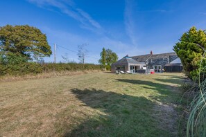 Ein Wohnhaus mit großem Rasen, einem separaten Haus und einer kleinen Gartenhütte.