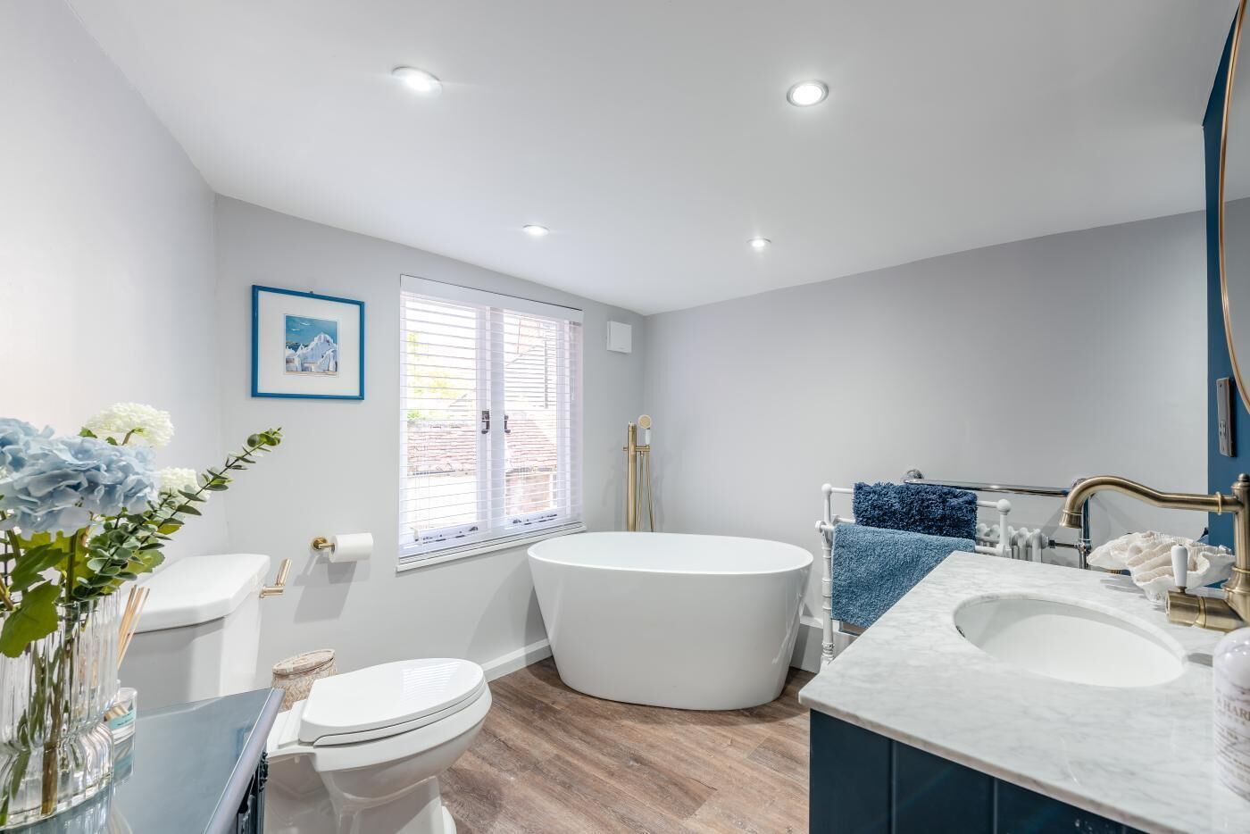 A modern bathroom with a freestanding bathtub, a toilet, and a sink.