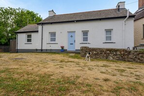 A two-story house with a stone wall and a blue door. - 1 Bed in St. Dogmaels (oc-m45322) (Saint Dogmaels)