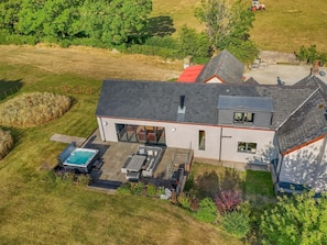 A modern two-story house with a large patio area, a hot tub, and a covered outdoor seating area. - 4 Bed in Llansannan (oc-p44897) (Llansannan)