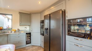 Een moderne keuken met grijze kastjes, roestvrijstalen apparatuur en een inbouwoven.
