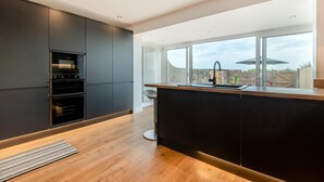 A modern kitchen with built-in appliances, a large window, and a view of the outdoors. - 3 Bed in Rustington (oc-p45430) (Rustington)