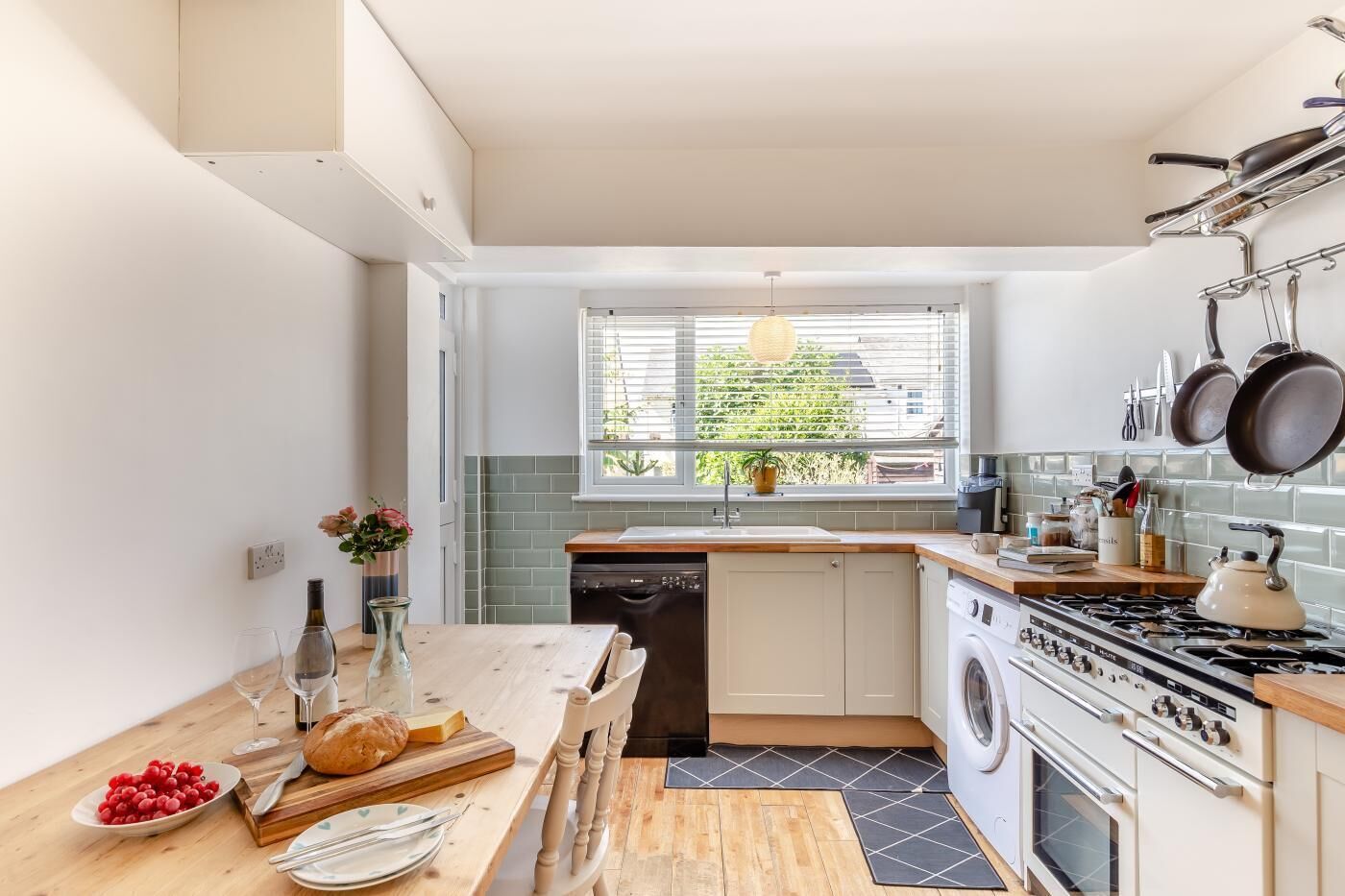 Une cuisine moderne avec une table en bois, un lave-linge et une cuisinière.