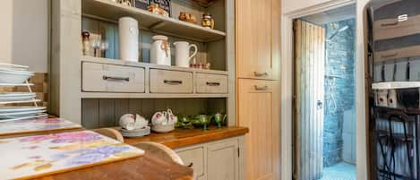 A kitchen with wooden cabinets, a countertop, and various kitchenware.