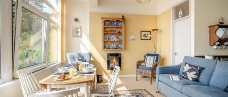 Una sala de estar acogedora con comedor, chimenea y estantería decorada con platos.