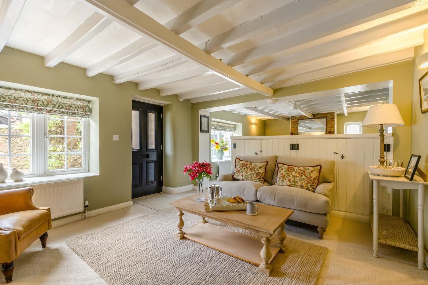 A cozy living room with a sofa, a coffee table, and a lamp.