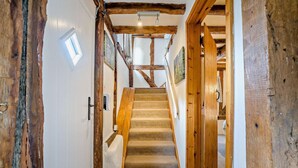A wooden staircase with a carpeted landing leading to a room with a white door and a small window. - 2 Bed in Cradley (oc-s45721) (Cradley and Storridge)