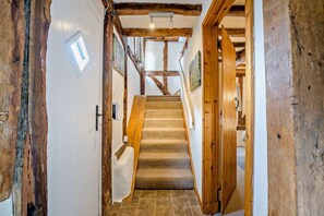A wooden staircase with a carpeted landing leading to a room with a white door and a small window. - 2 Bed in Cradley (oc-s45721) (Cradley and Storridge)