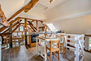 A rustic kitchen with wooden beams, a dining area with a white fence, and a view of the outdoors. - 2 Bed in Cradley (oc-s45721) (Cradley and Storridge)