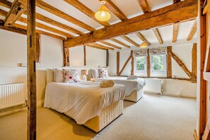 A bedroom with a wooden ceiling, two beds, a window, and a radiator. - 2 Bed in Cradley (oc-s45721) (Cradley and Storridge)