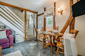 A cozy room with a dining table, chairs, a sofa, and a staircase. - 1 Bed in Cradley (oc-w45725) (Cradley and Storridge)