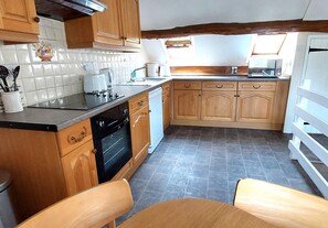 A kitchen with wooden cabinets, a black oven, and a tiled backsplash. - 2 Bed in Cradley (oc-h45727) (Cradley and Storridge)