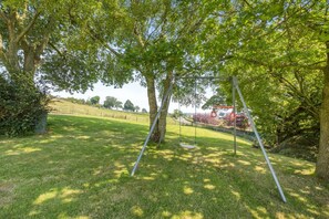 A grassy outdoor area with a swing set and a climbing structure. - 5 Bed in Melmerby (oc-m45569) (Melmerby)
