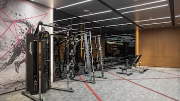 Une salle de sport équipée de divers appareils d’entraînement, notamment des machines à poids et des poids libres.