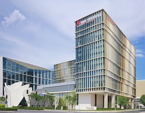 Un hotel moderno con un llamativo letrero 'Marriott Marquis', fachada de vidrio y un diseño arquitectónico único.