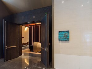 A modern interior with a wooden door leading to a seating area.