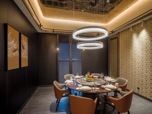 Un comedor moderno con una mesa redonda, sillas y un centro de mesa decorativo.