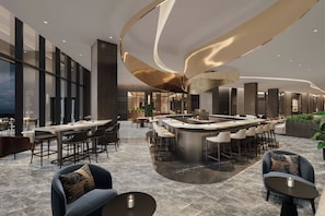A modern bar area with a curved ceiling and seating arrangements. - JW Marriott Detroit Water Square (Detroit)