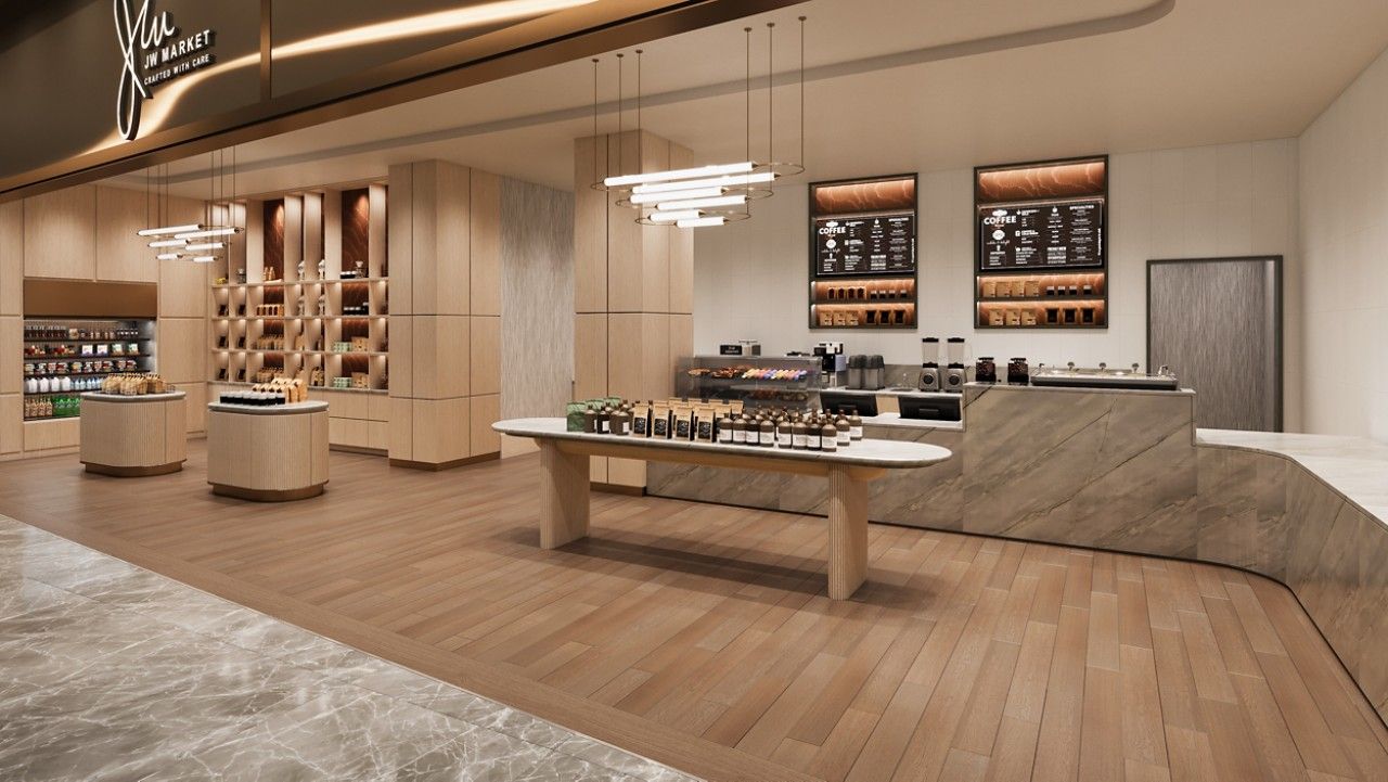 Un intérieur moderne avec un plancher en bois, une table centrale servant de présentoir et un espace bar à café.