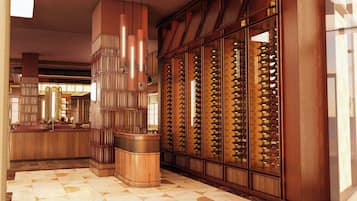 A hotel lobby with a wine cellar, a bar area, and a patterned floor.