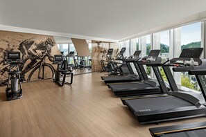 A gym with multiple treadmills, stationary bikes, and a rowing machine.
