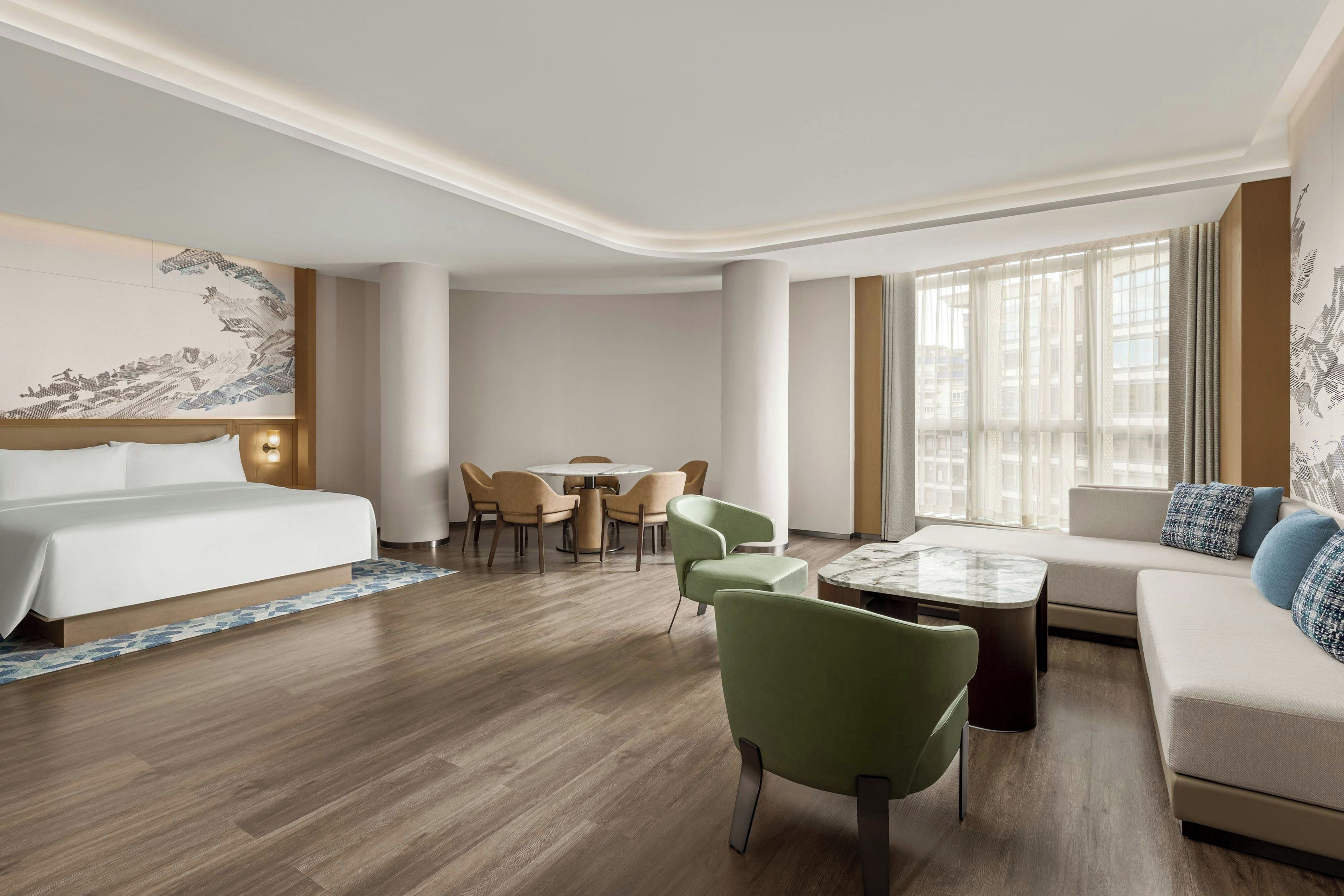A hotel room with a bed, a dining table with chairs, a sofa, and a coffee table.