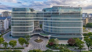 A modern hotel with a curved glass facade, a central courtyard with a fountain, and a view of the surrounding cityscape. - Courtyard By Marriott Guilin Downtown (Guilin)