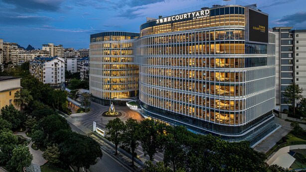 A modern hotel with a curved facade, multiple floors, and a prominent signage. - Courtyard By Marriott Guilin Downtown (Guilin)
