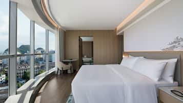 Una habitación de hotel con una cama grande, un escritorio y vistas a la ciudad.