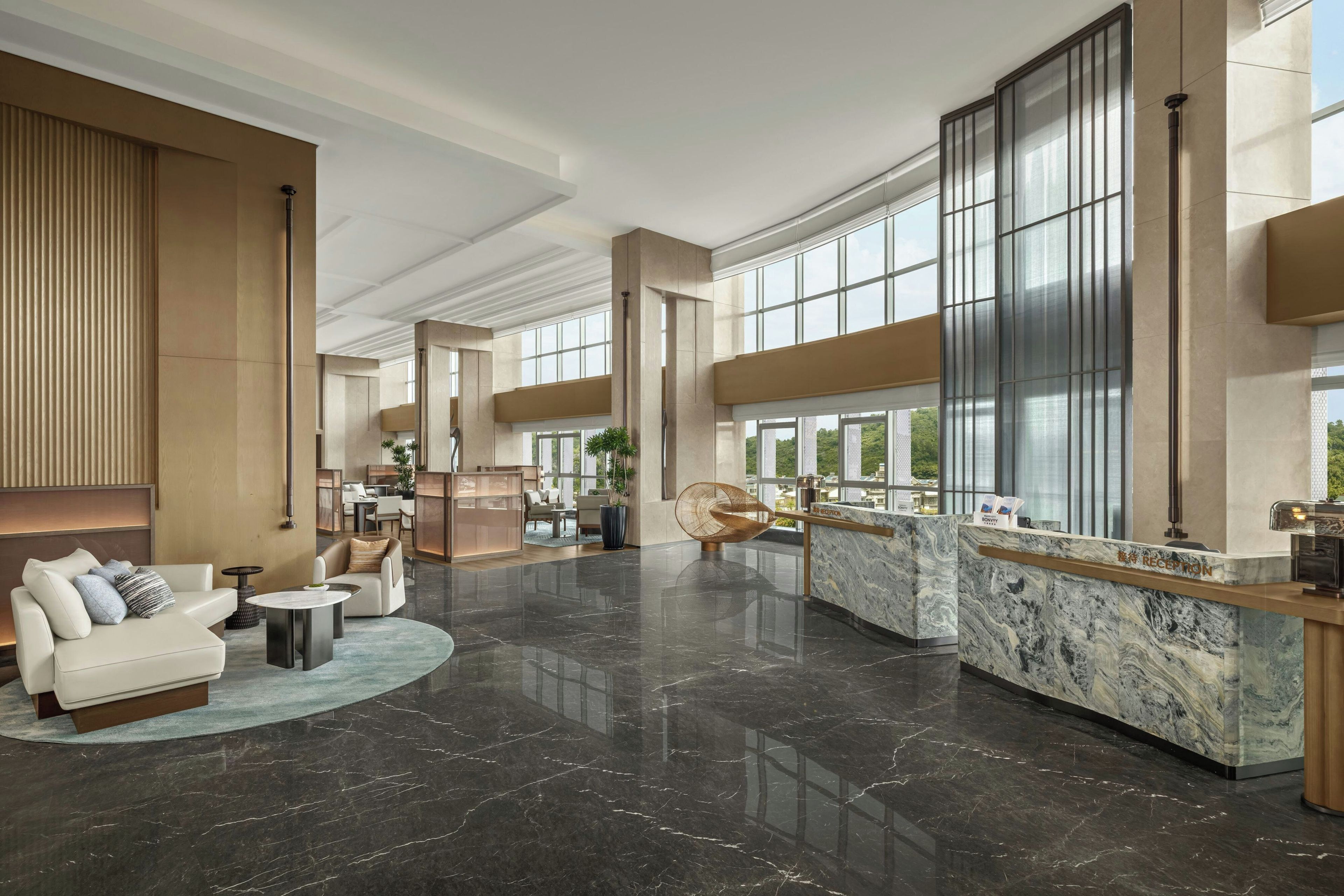 A spacious lobby with a reception desk, seating area, and large windows offering views.