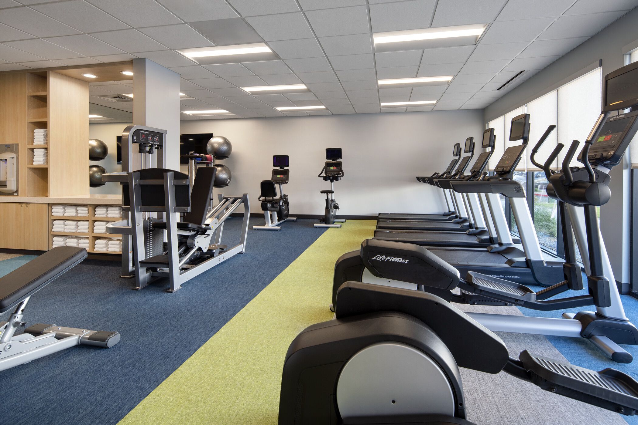 A gym with treadmills, elliptical machines, and weight equipment.