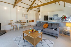 Ein Wohnzimmer mit einer Couch, einem Couchtisch und einem Essbereich mit Stühlen.