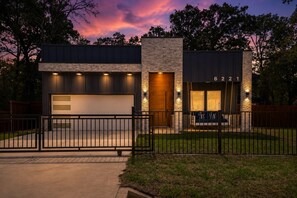 A modern two-story house with a stone facade, a garage, and a fenced yard. - Hot Tub+Game Room+Pet-Friendly+Lake Access+FirePit (Mabank)