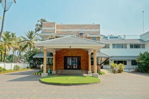 A hotel entrance with a covered porch, a central staircase, and a paved driveway. - Hotel Bluewaters Cherai (Kochi)