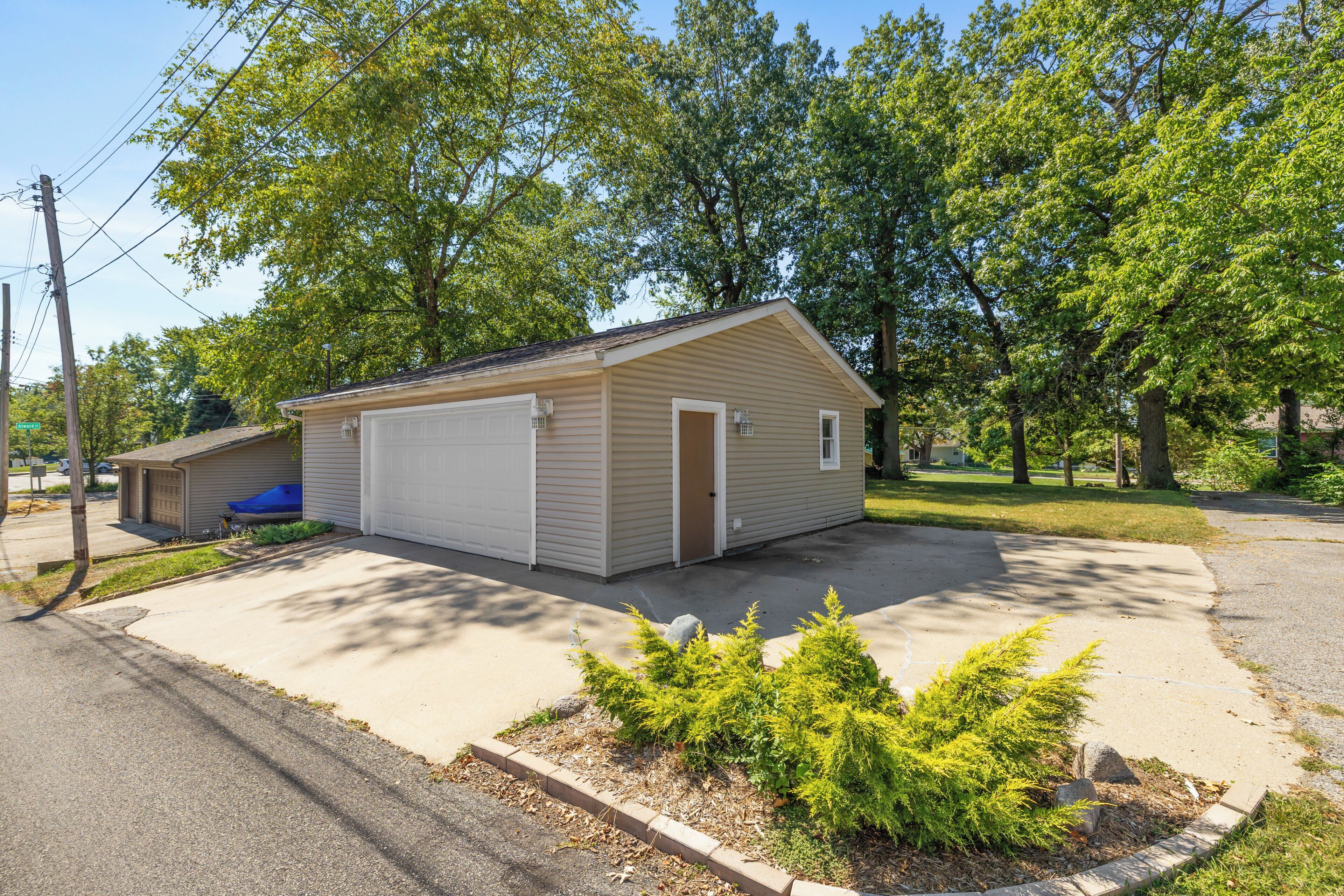 A single-story house with a garage, a small attached shed, and a driveway.