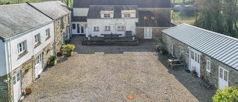 Ein Innenhof mit Kiespflaster, umgeben von Gebäuden mit Steinmauern und Ziegeldächern.