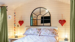 A bedroom with a bed, a mirror, heart-shaped decorations, and a string of colorful balls. - 1 Bed in Shipley (oc-s34110) (Shipley)