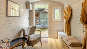 A cozy room with a wooden bench, a chair, a small table, and a door leading to an outdoor area with a balcony. - 1 Bed in Shipley (oc-s34110) (Shipley)